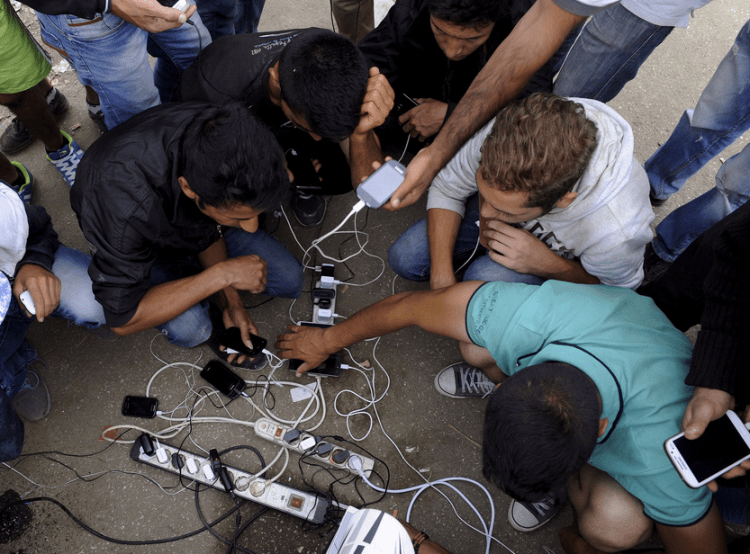 Refugees and migrants charge their mobile phones as they wait to cross the borders of Greece with Macedonia (Alexandros Avramidis/Reuters) 