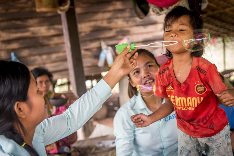 Disability workers playing speech therapy games with six-year old Tai. (Photo: Anna Betts/OIC: The Cambodia Project)